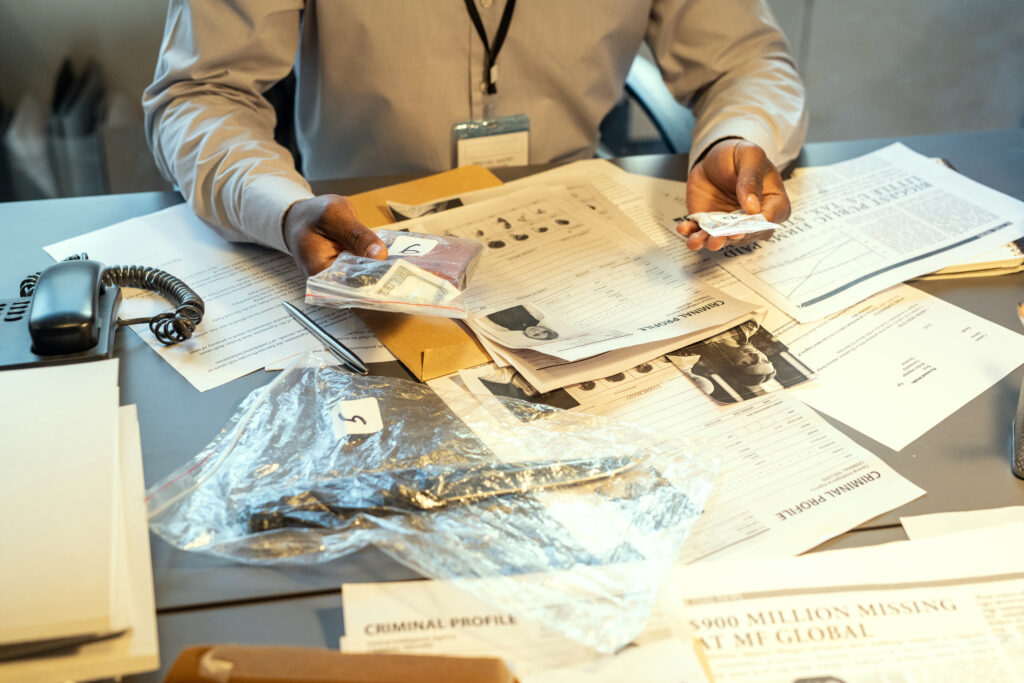 Hands of private investigator holding evidences in packets 